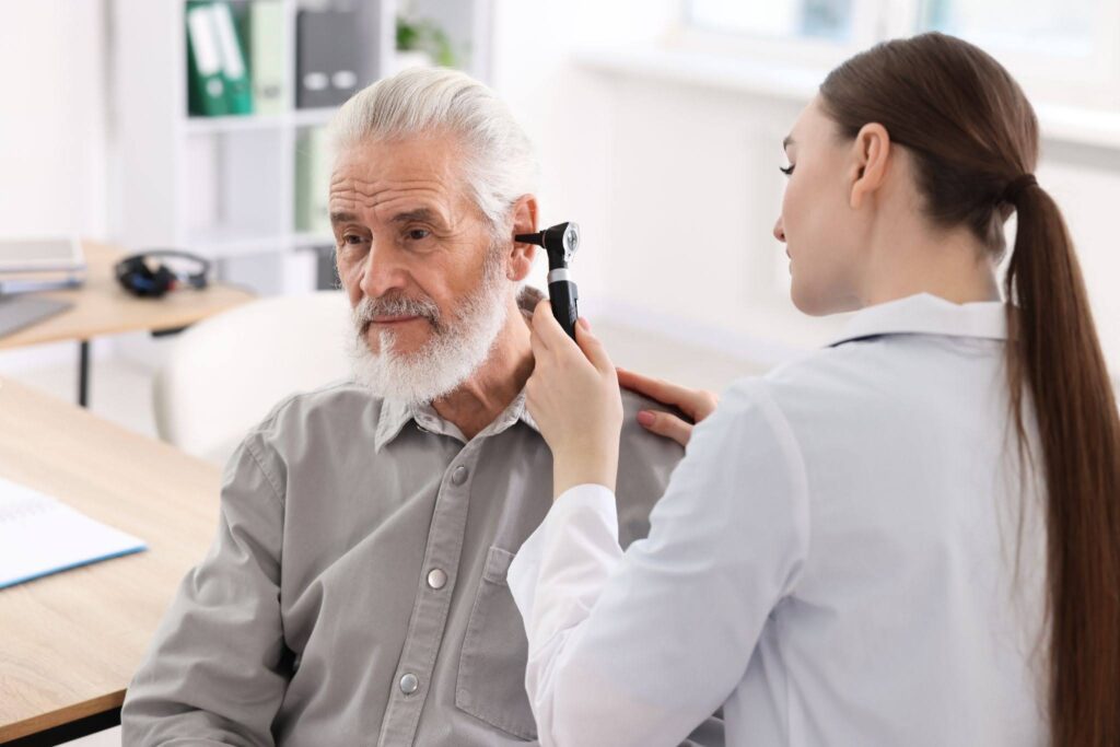 An audiologist checking a patient‘s ear